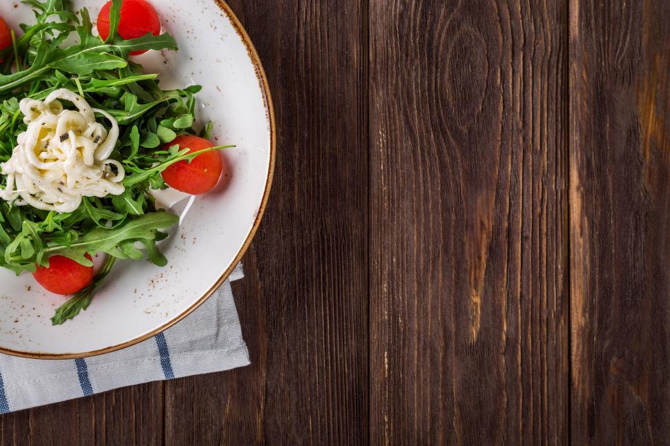Free Image of A plate of salad on a wood surface 