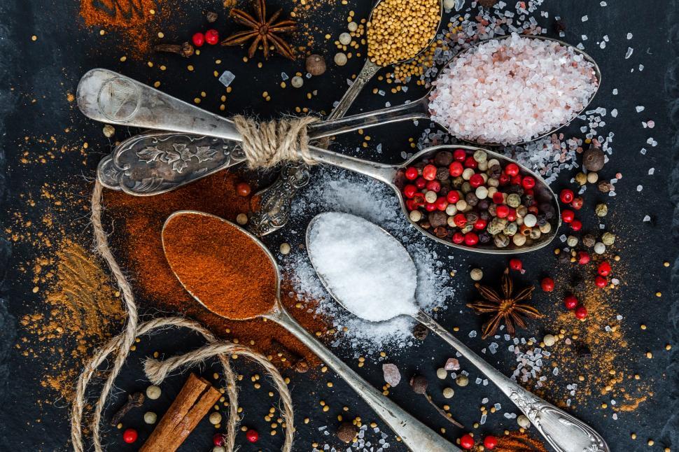 Free Image of Spoons with different spices and powders on a black surface 