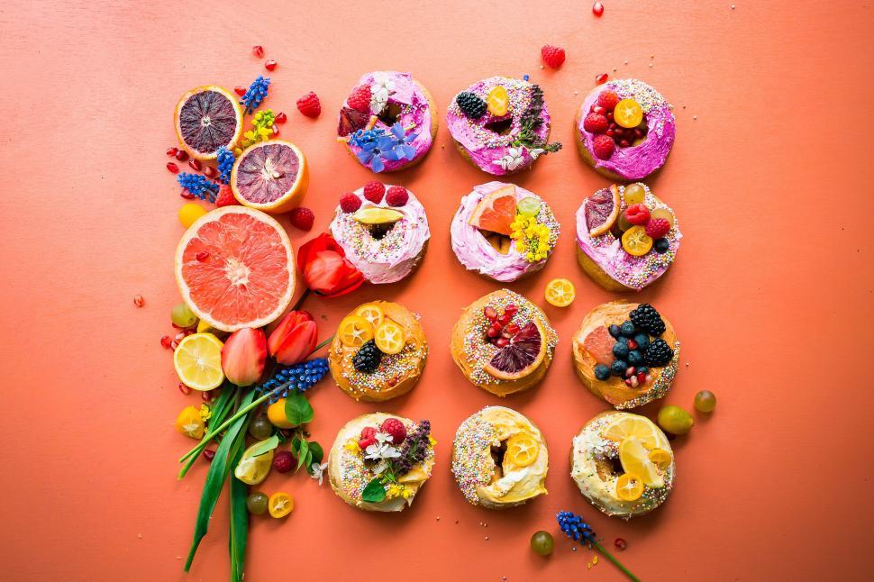 Free Image of A group of donuts with fruit and flowers 
