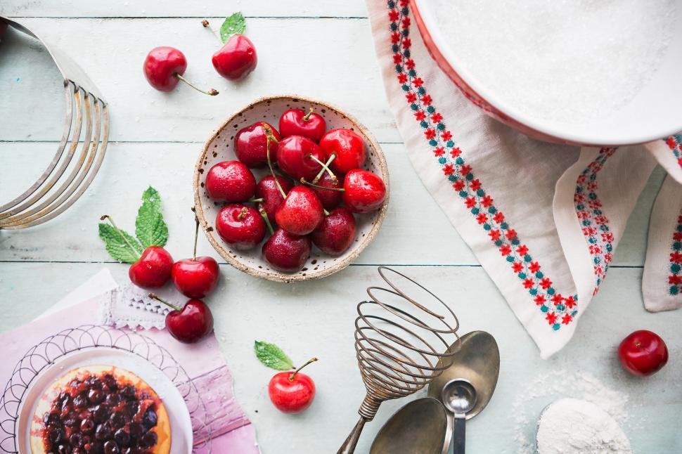 Free Image of A bowl of cherries and utensils 