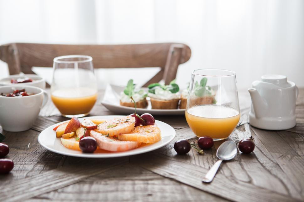 Free Image of A plate of fruit and a glass of juice on a table 