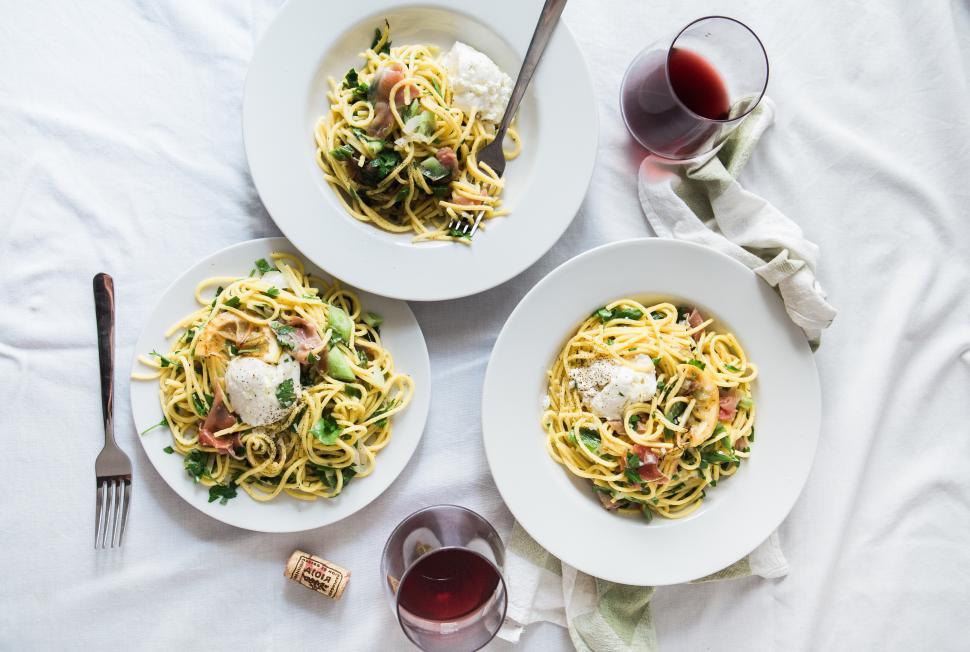 Free Image of A group of plates of pasta and wine 