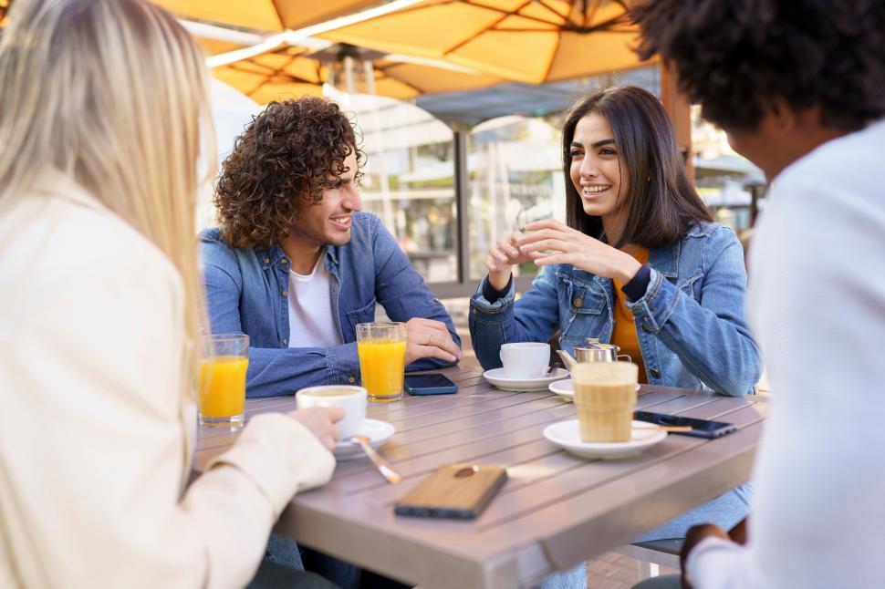 Free Image of Multi-ethnic group of friends having a drink together in an outdoor bar. 