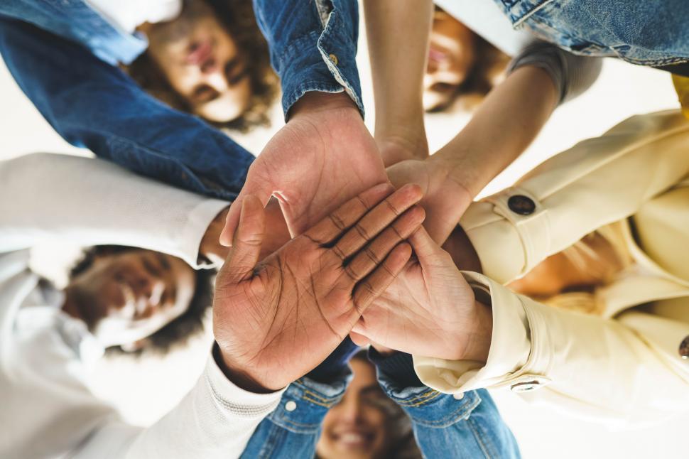 Free Image of Hands of a multi-ethnic group of friends joined together as a sign of support and teamwork. 