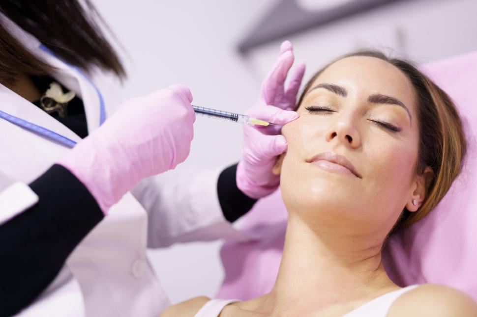 Free Image of Doctor injecting hyaluronic acid into the cheekbones of a woman as a facial rejuvenation treatment. 
