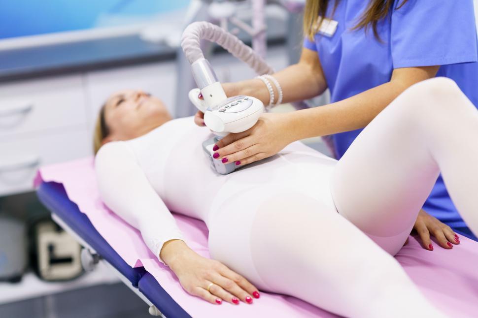 Free Image of Woman in special suit having a anti cellulite belly massage with spa apparatus 