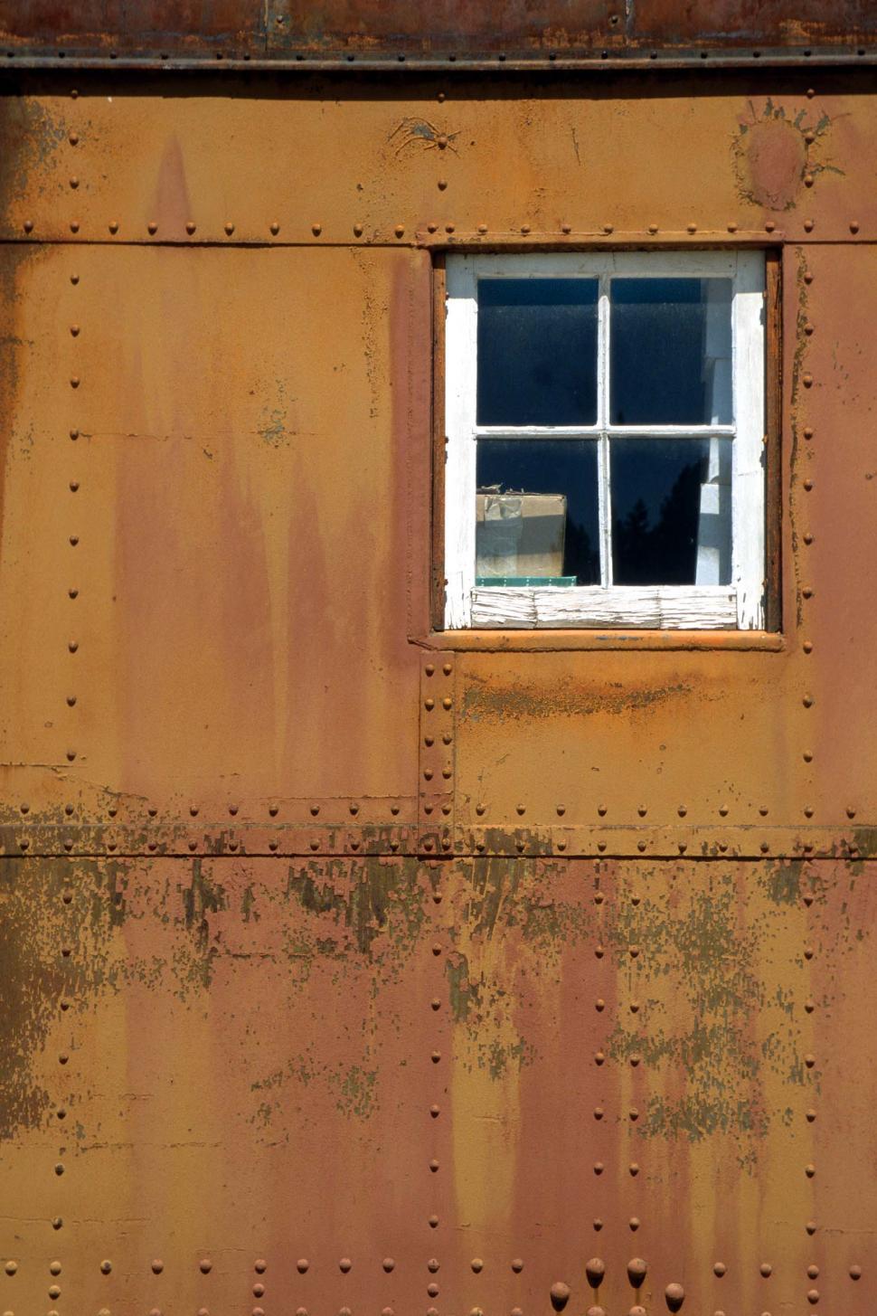 Free Image of Faded paint on train car with window 