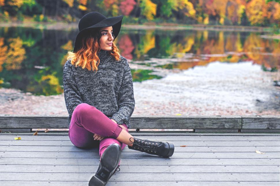 Free Image of A woman sitting on a dock 