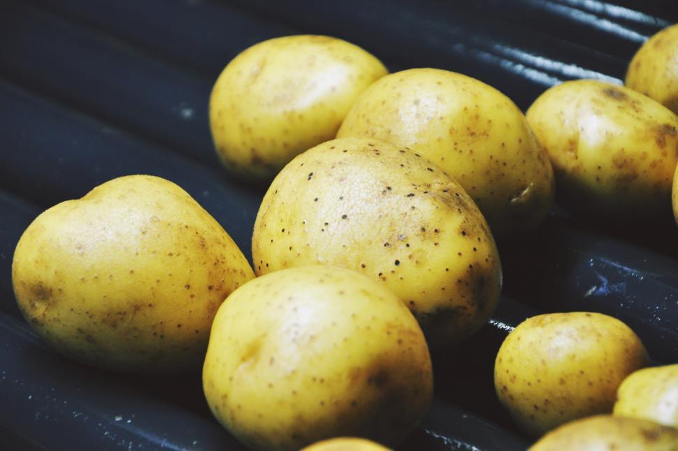 Free Image of A group of potatoes on a black surface 