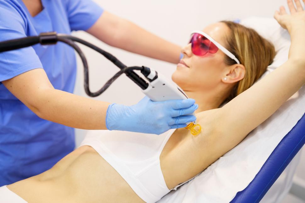 Free Image of Woman receiving underarm laser hair removal at a beauty center. 