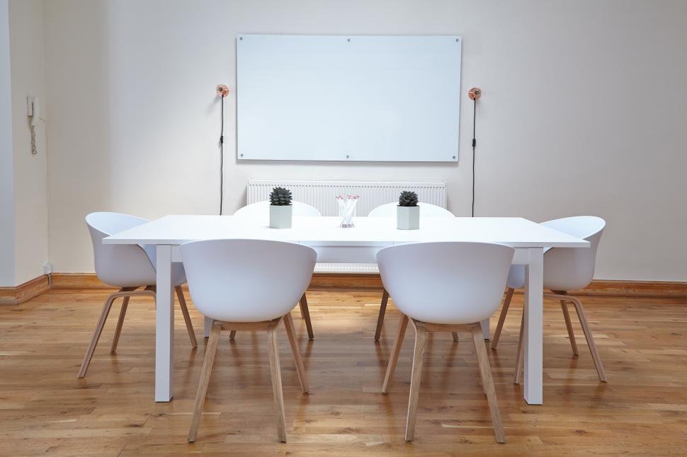 Free Image of A white table and chairs in a room 
