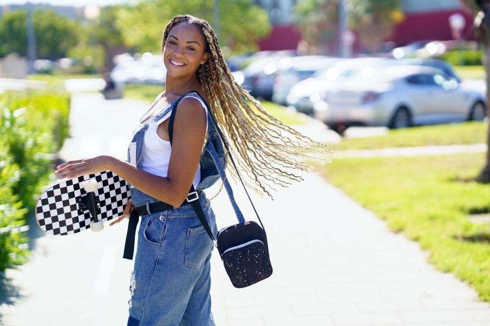 Free Image of Black girl on street, moving her coloured braids in the wind. Typical African hairstyle. 