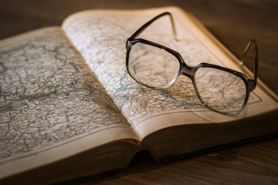 Free Image of A pair of glasses on an open book 