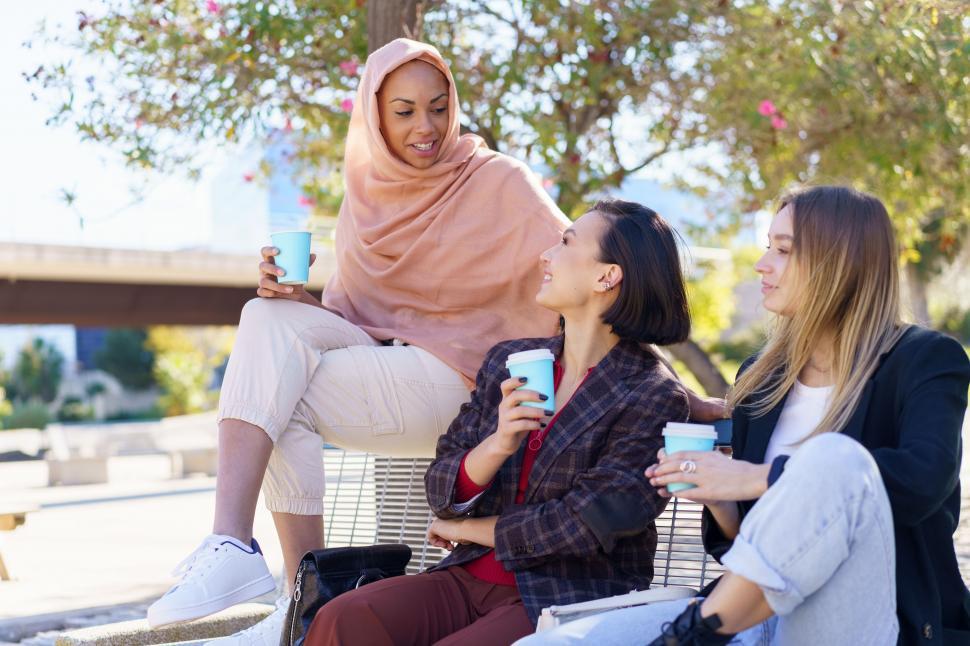 Free Image of Happy diverse women having coffee break and chatting outdoors 