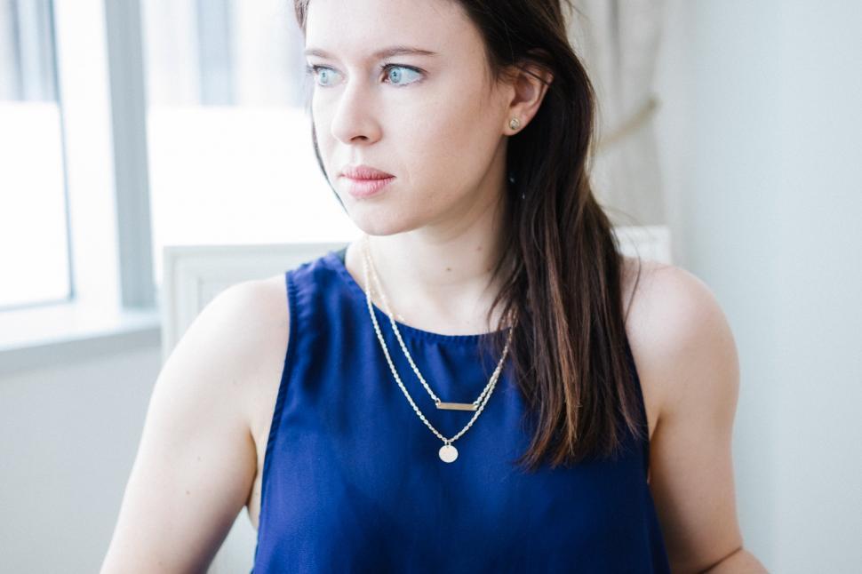 Free Image of A woman wearing a blue top and necklace 