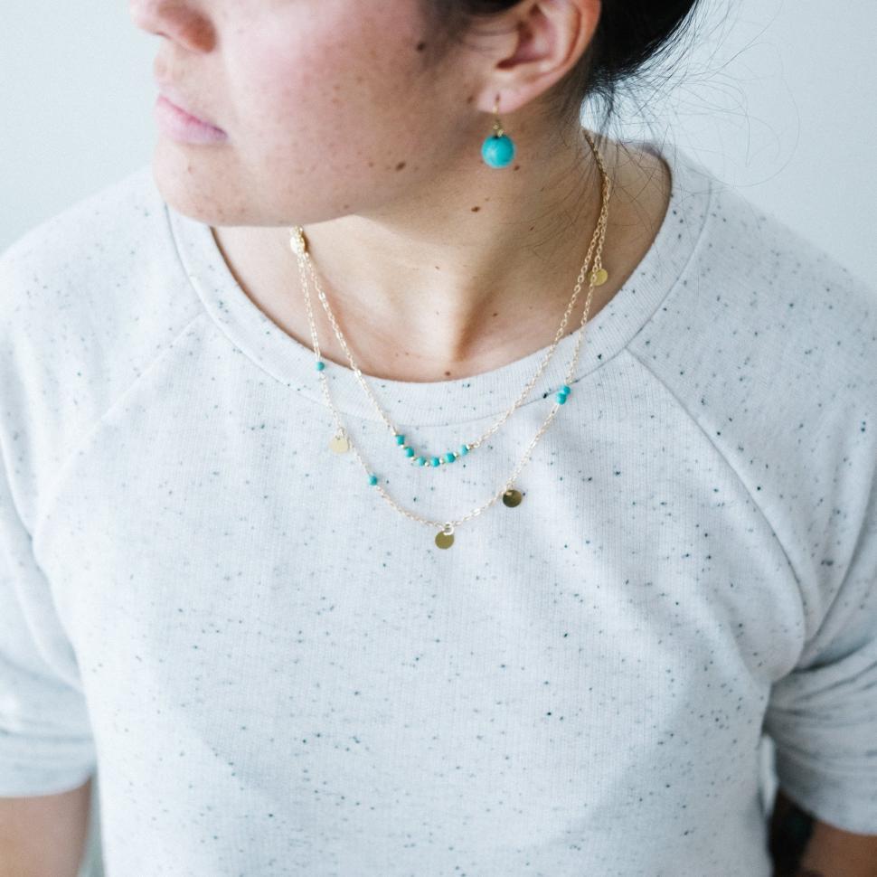 Free Image of A woman wearing a necklace and earrings 