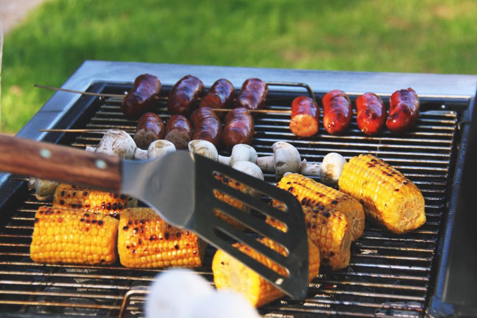 Free Image of A grill with corn and sausages on it 
