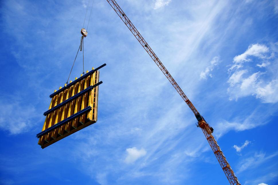 Free Image of A crane lifting a wooden structure 