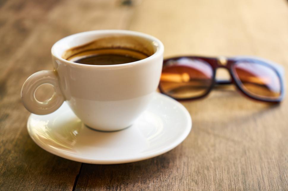 Free Image of A cup of coffee and sunglasses on a table 