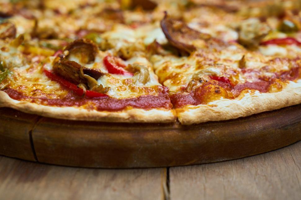 Free Image of A pizza with toppings on a wooden board 