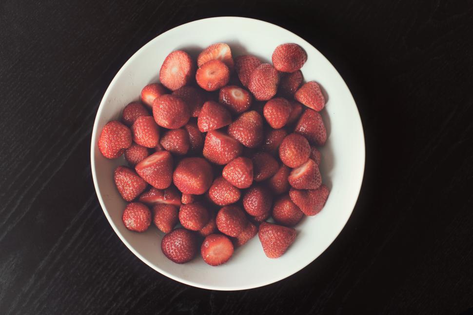 Free Image of A bowl of strawberries on a black table 
