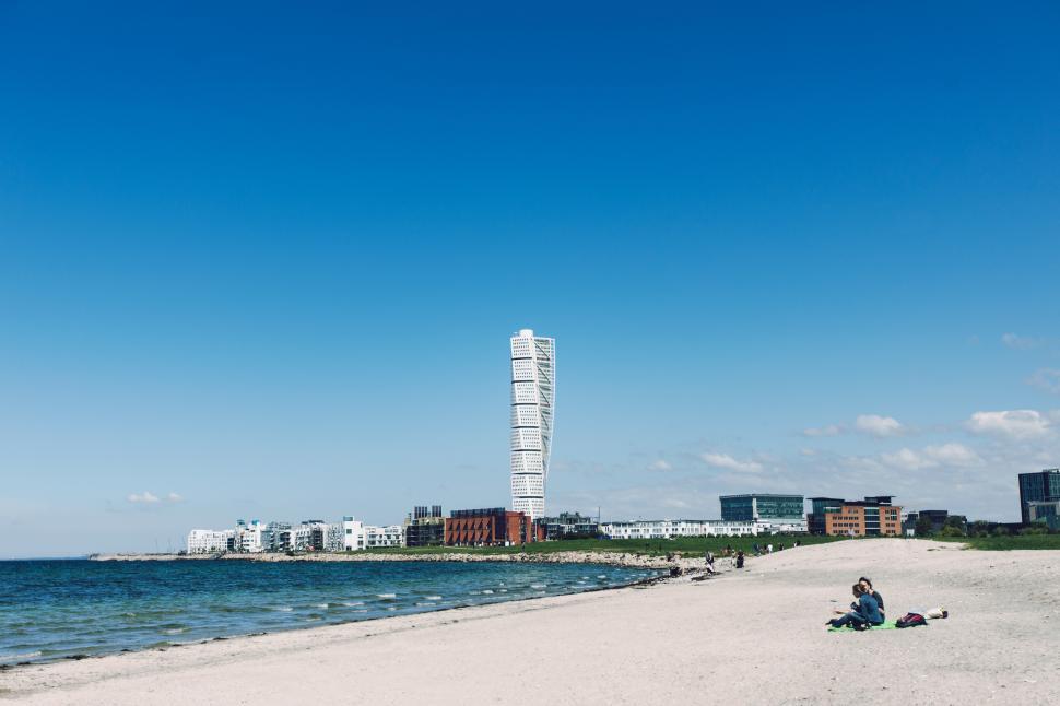 Free Image of A beach with a tall building in the background 