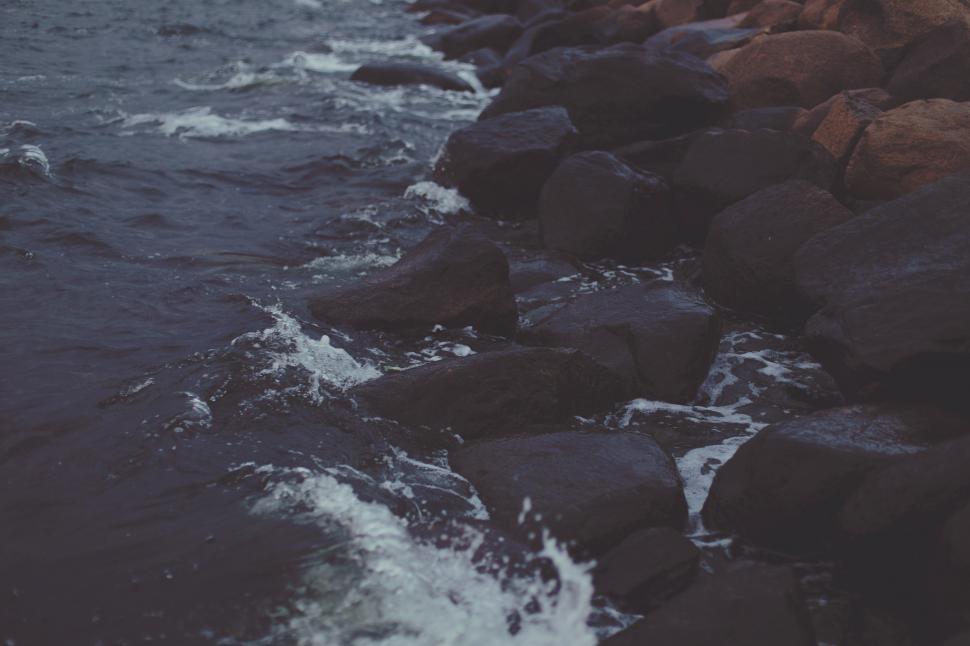 Free Image of A rocky shore with waves crashing on rocks 