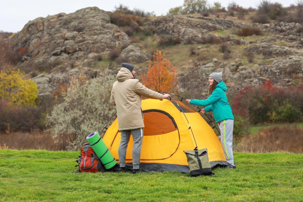 Free Image of A man and woman setting up a tent 