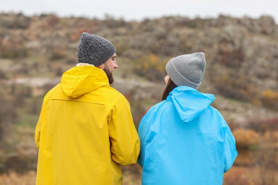 Free Image of A man and woman in raincoats looking at each other 