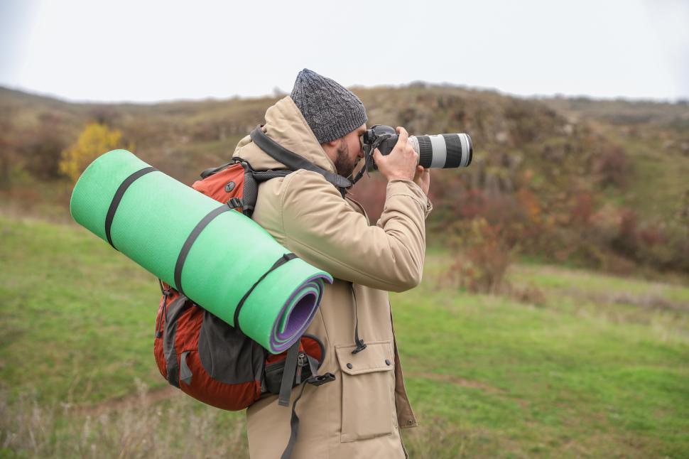 Free Image of A man with a backpack and a large camera 