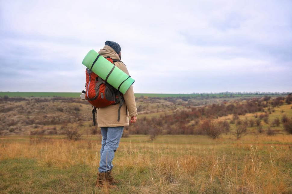 Free Image of A person with a backpack standing in a field 