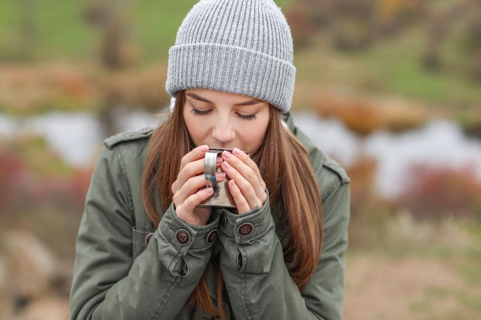 Free Image of A woman in a beanie drinking from a mug 