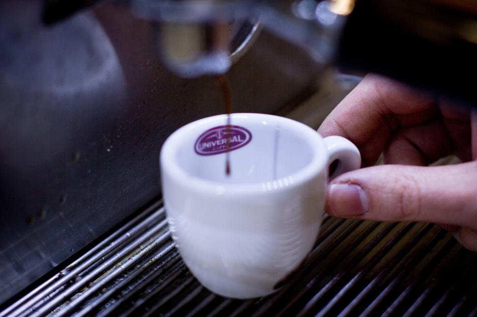 Free Image of A person pouring a coffee into a cup 