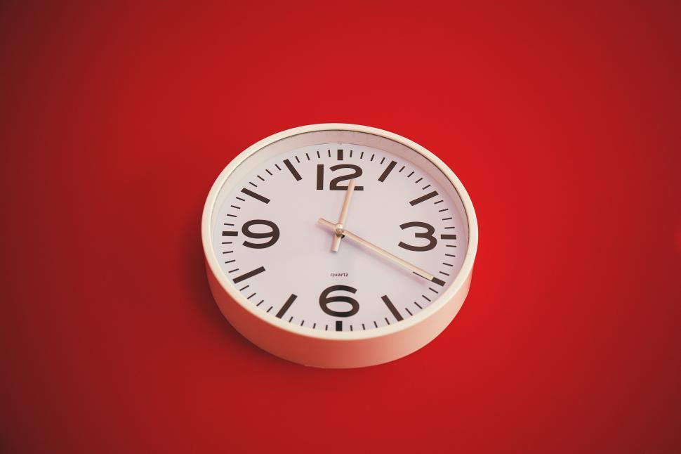 Free Image of A white clock on a red background 