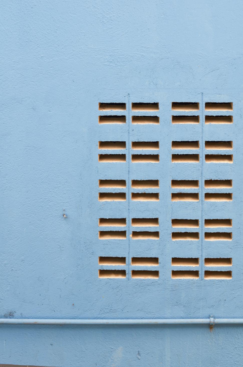 Free Image of A blue wall with holes in it 