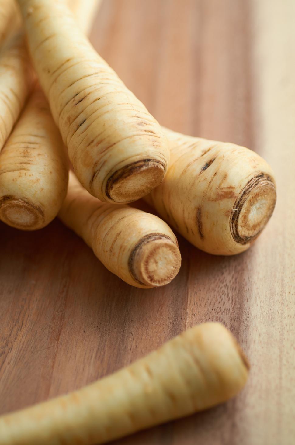 Free Image of A group of parsnips on a wood surface 