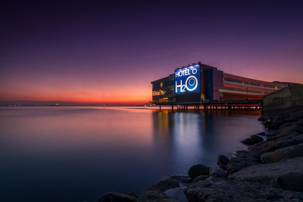 Free Image of A building with a sign on it and a body of water 