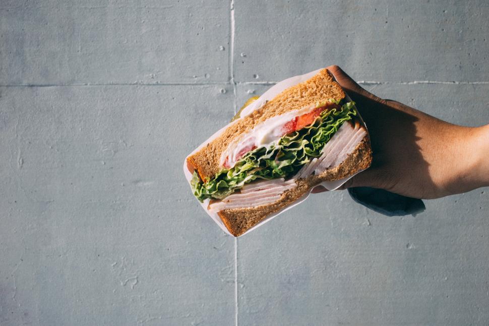 Free Image of A hand holding a sandwich 
