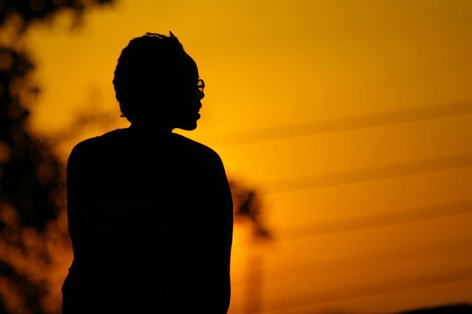 Free Image of A silhouette of a man in front of a sunset 