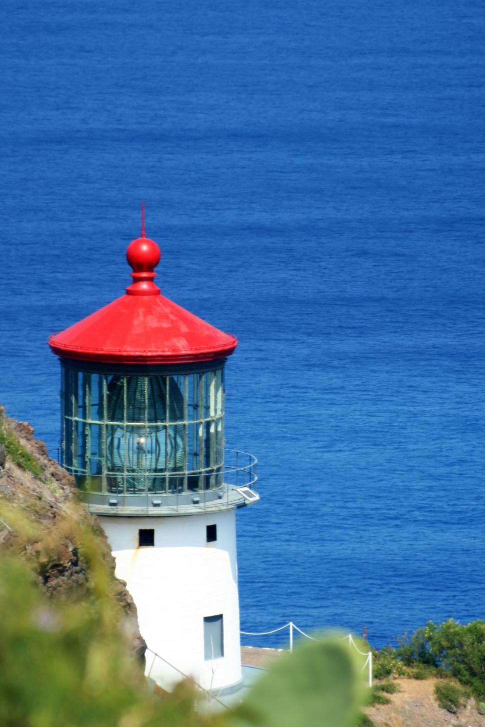 Free Image of A lighthouse on a cliff by the water 