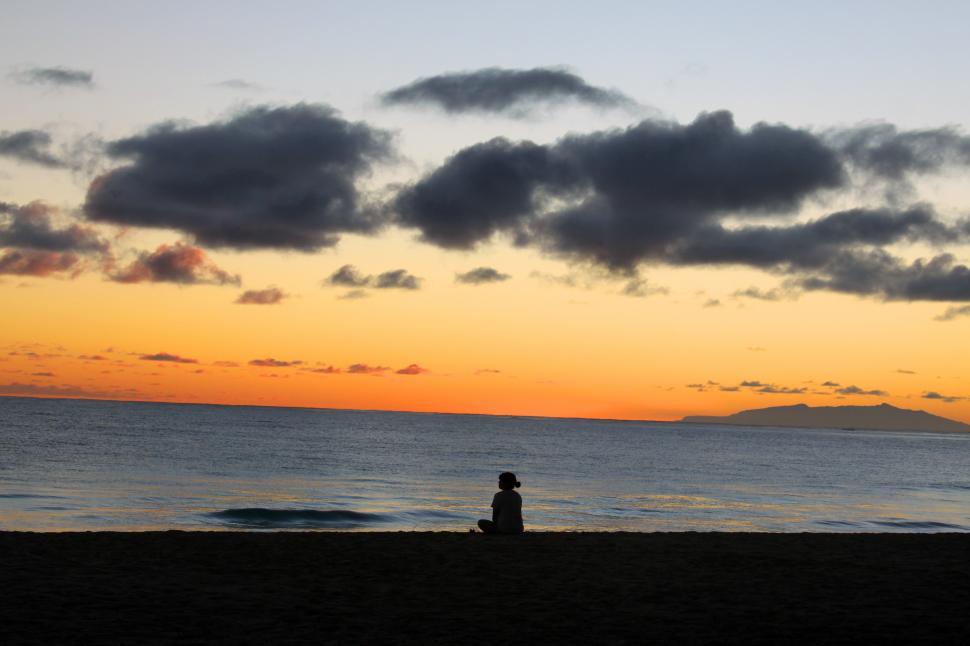 Free Image of A person sitting on the beach 