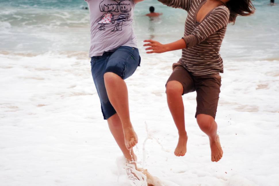 Free Image of Two people running on the beach 