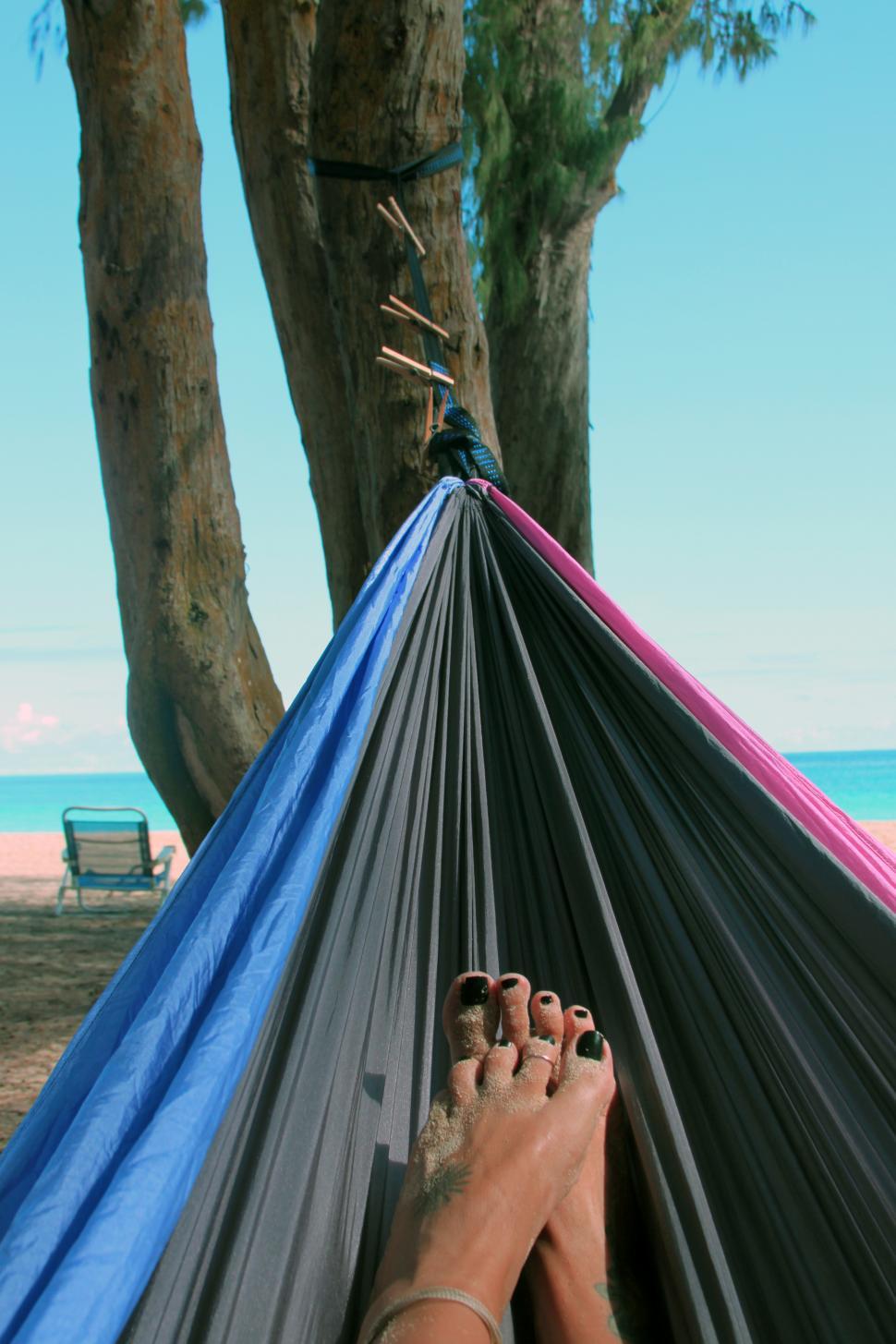 Free Image of A person s feet in a hammock on a beach 