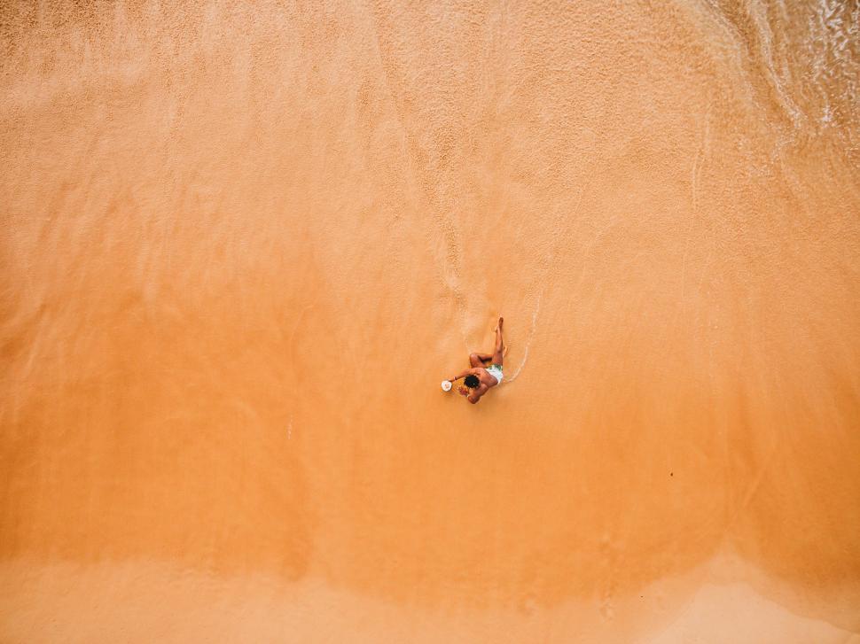 Free Image of A person lying on the beach 