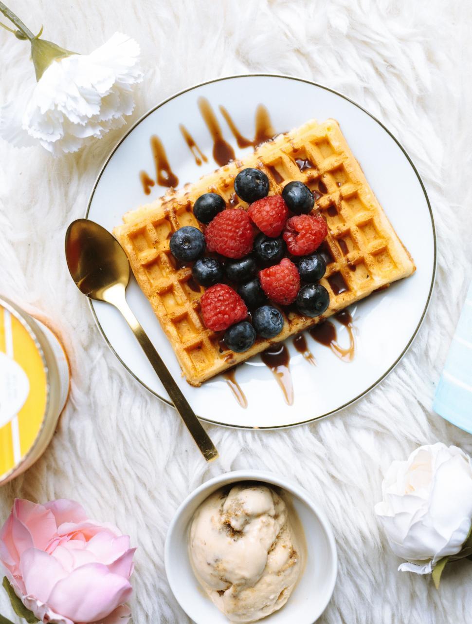 Free Image of A plate of waffles with berries and syrup on top 