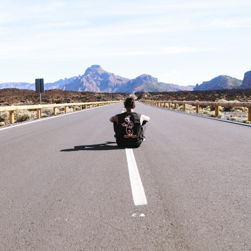 Free Image of A person sitting on the road 