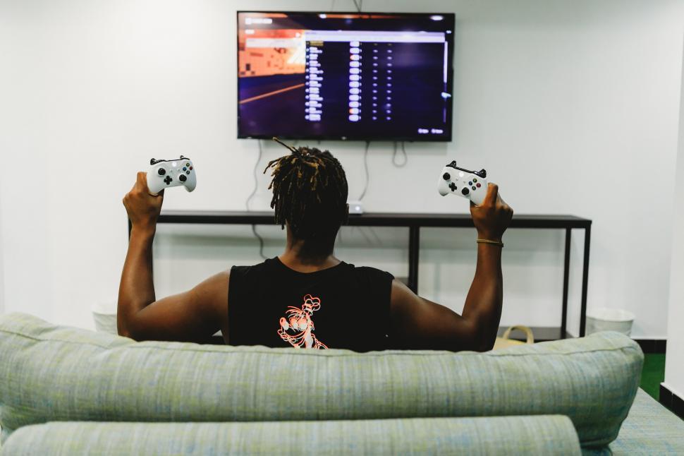 Free Image of A man sitting on a couch holding game controllers 