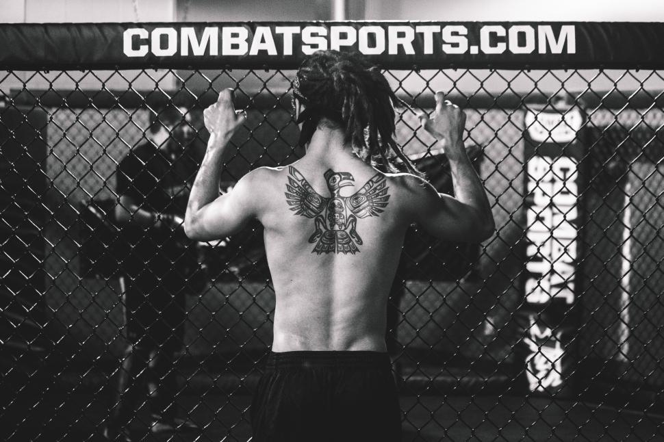 Free Image of A man with a tattoo on his back in a cage 