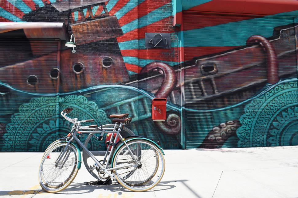 Free Image of A bicycle parked in front of a painted wall 