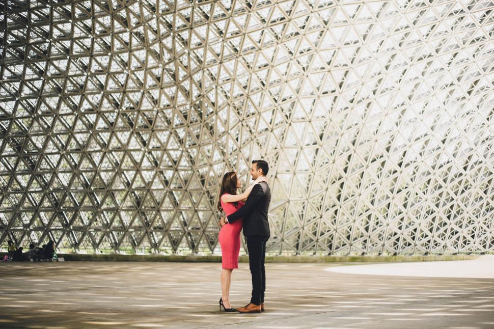 Free Image of A man and woman hugging in front of a glass dome 